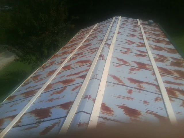 Rusted metal roof panels with new wood purlins before replacement — Storm Damage Roof Repair in Feura Bush by Roofing Brothers